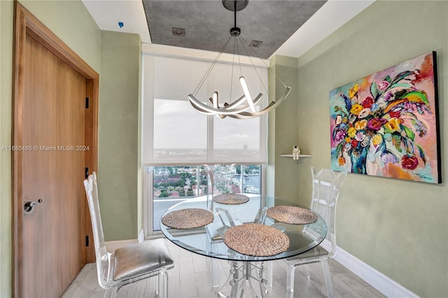 dining area featuring a notable chandelier and light wood-type flooring