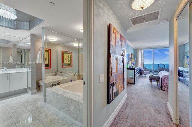 bathroom featuring vanity, a wall of windows, toilet, and tiled bath