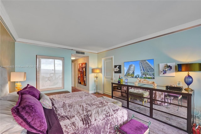 bedroom with hardwood / wood-style floors and crown molding