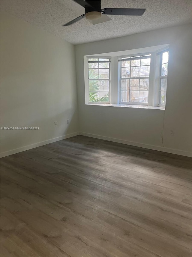 empty room with hardwood / wood-style floors, a textured ceiling, and ceiling fan