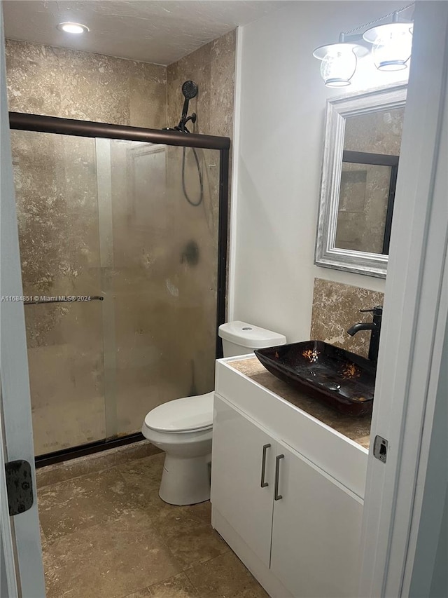 bathroom with vanity, a shower with shower door, and toilet