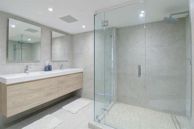 bathroom featuring tile walls, vanity, and a shower with shower door