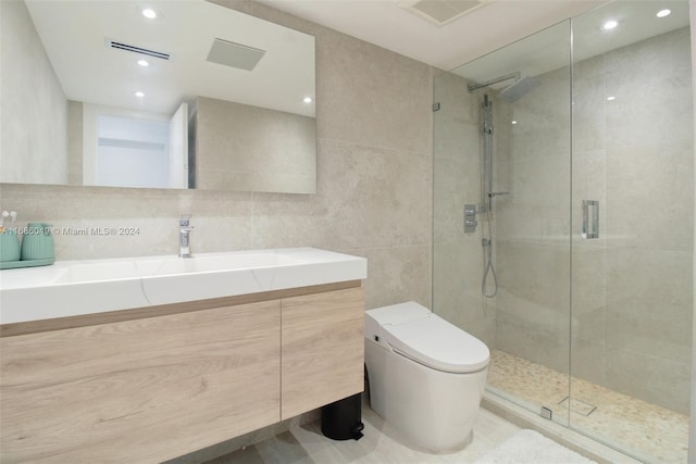 bathroom with vanity, toilet, tile walls, and a shower with door