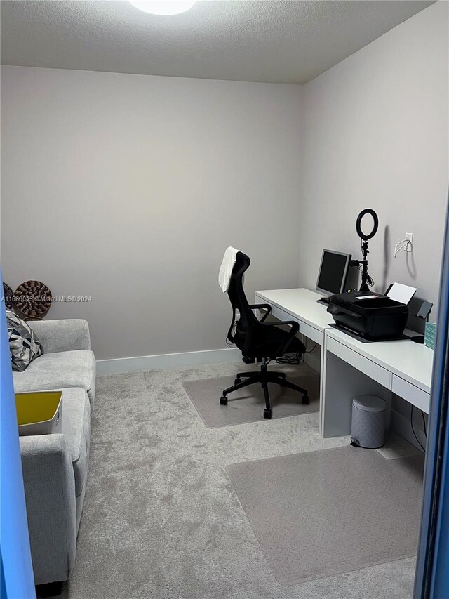 home office with a textured ceiling and carpet floors