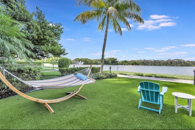 view of community featuring a lawn and a water view