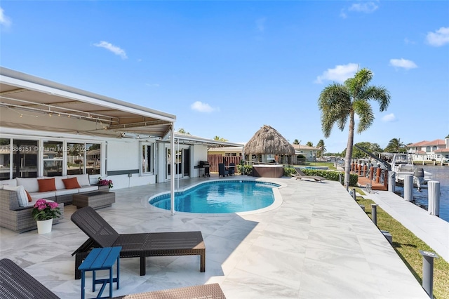 view of pool featuring a patio area, area for grilling, a water view, and an outdoor living space