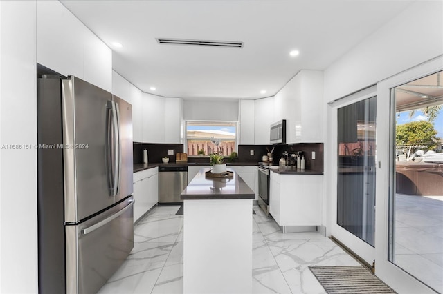 kitchen with decorative backsplash, appliances with stainless steel finishes, a wealth of natural light, and a kitchen island