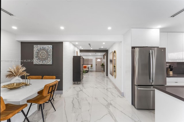 kitchen with white cabinetry and stainless steel fridge