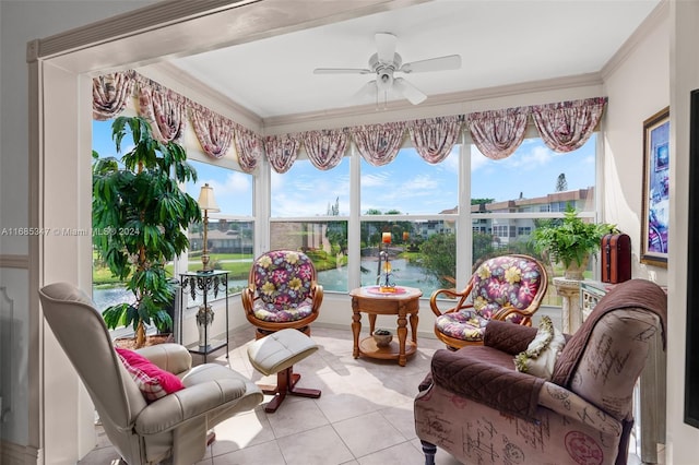 sunroom / solarium with a healthy amount of sunlight, a water view, and ceiling fan