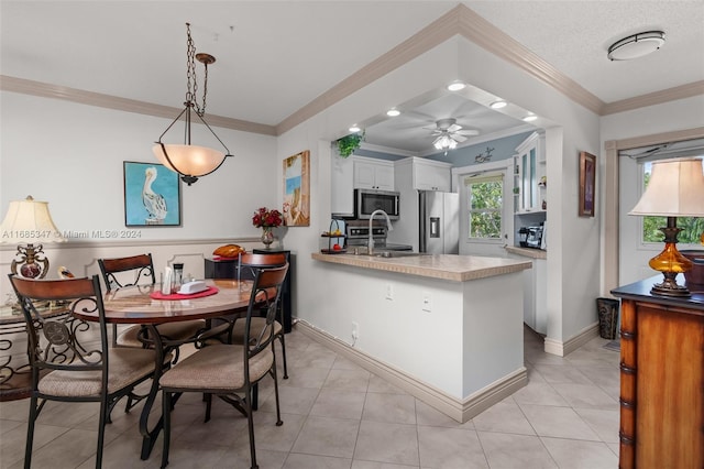 kitchen featuring kitchen peninsula, ceiling fan, white cabinetry, ornamental molding, and stainless steel appliances