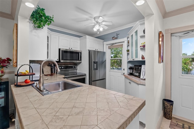 kitchen with a healthy amount of sunlight, sink, appliances with stainless steel finishes, and white cabinetry