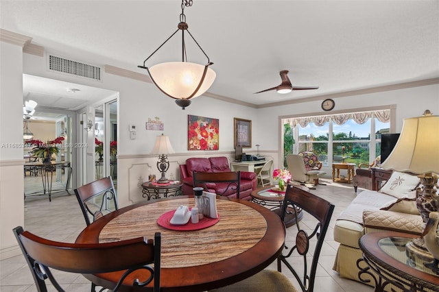 dining room with crown molding, light tile patterned flooring, and ceiling fan