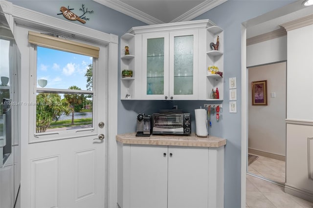 entryway featuring crown molding and light tile patterned floors