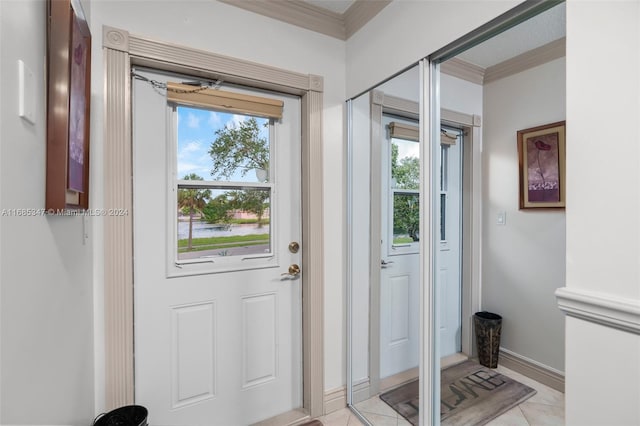 doorway to outside featuring crown molding, light tile patterned flooring, and a water view