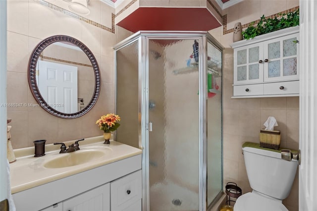 bathroom featuring vanity, tile walls, and toilet