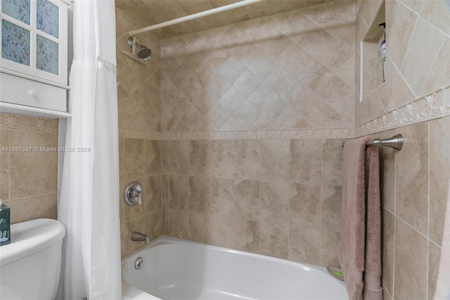 bathroom featuring toilet and shower / bathtub combination with curtain