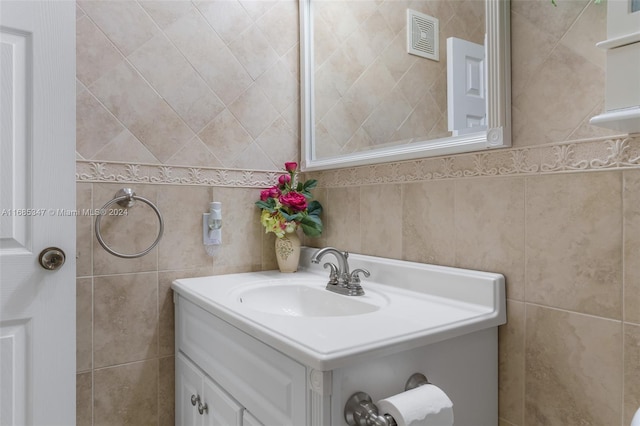 bathroom with vanity and tile walls