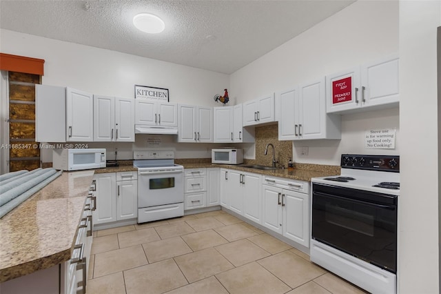 kitchen with sink, light tile patterned flooring, white cabinets, a textured ceiling, and white appliances