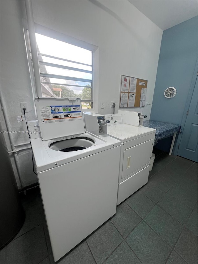 clothes washing area featuring washer and dryer and dark tile patterned flooring