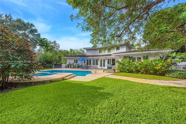 view of pool with a patio area and a lawn