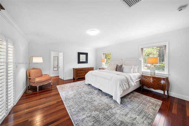 bedroom featuring crown molding and dark hardwood / wood-style floors