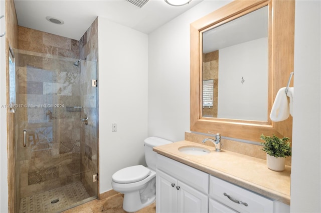 bathroom with tile patterned flooring, vanity, a shower with shower door, and toilet