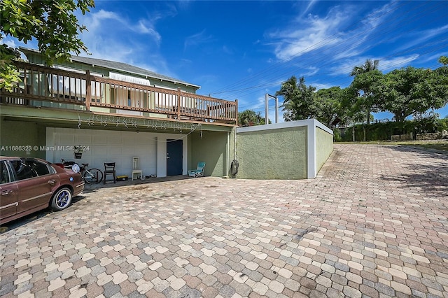 back of house with a garage and a deck