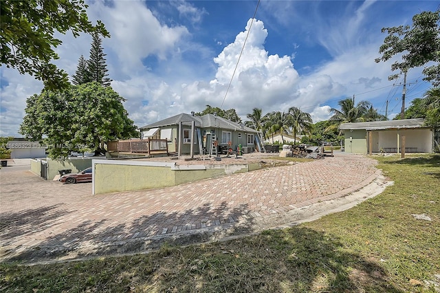 back of property with a garage and a lawn