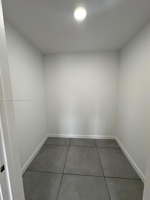 unfurnished room featuring dark tile patterned floors