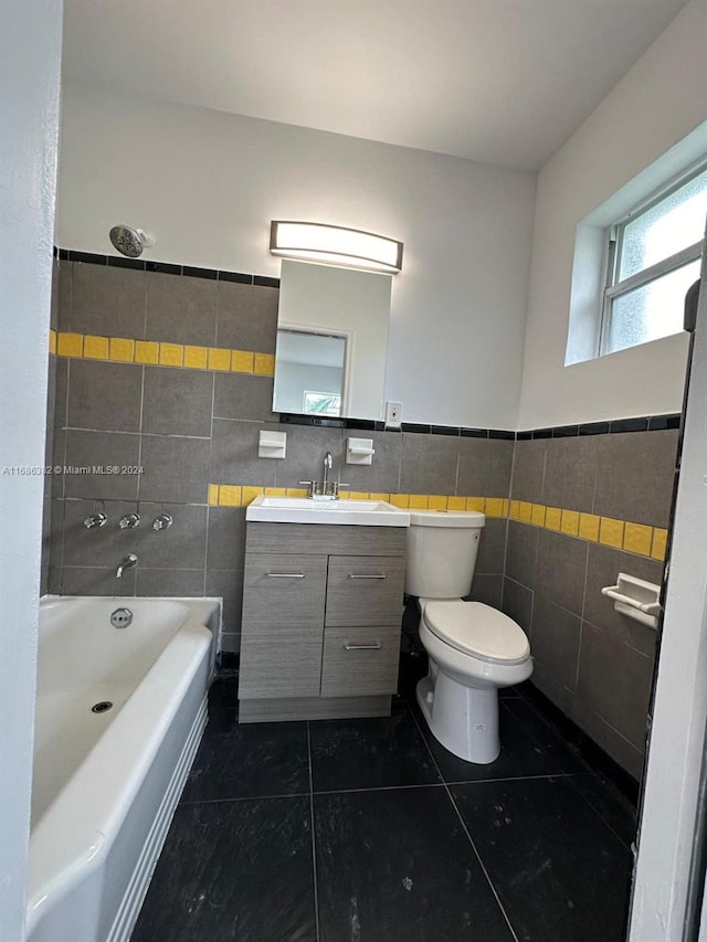 full bathroom featuring tile walls, toilet, vanity, washtub / shower combination, and tile patterned flooring