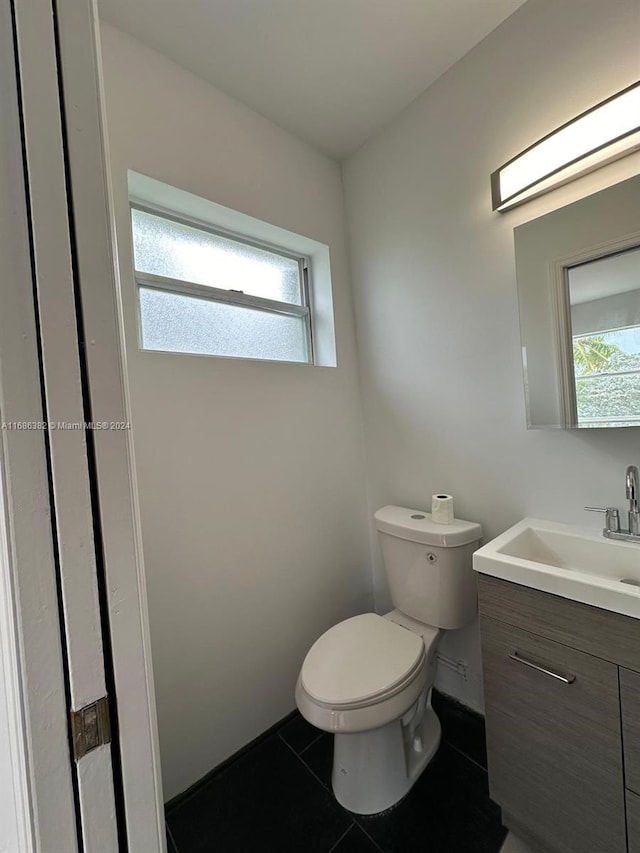 bathroom featuring toilet, vanity, and tile patterned flooring