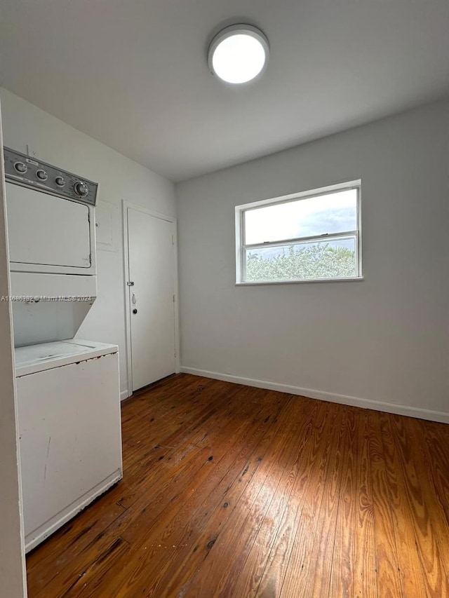 washroom with dark wood-type flooring and stacked washer and clothes dryer