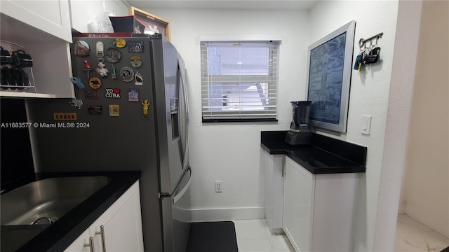 kitchen featuring white cabinetry and stainless steel refrigerator