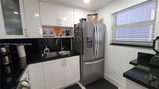 kitchen featuring sink, white cabinetry, and stainless steel refrigerator with ice dispenser