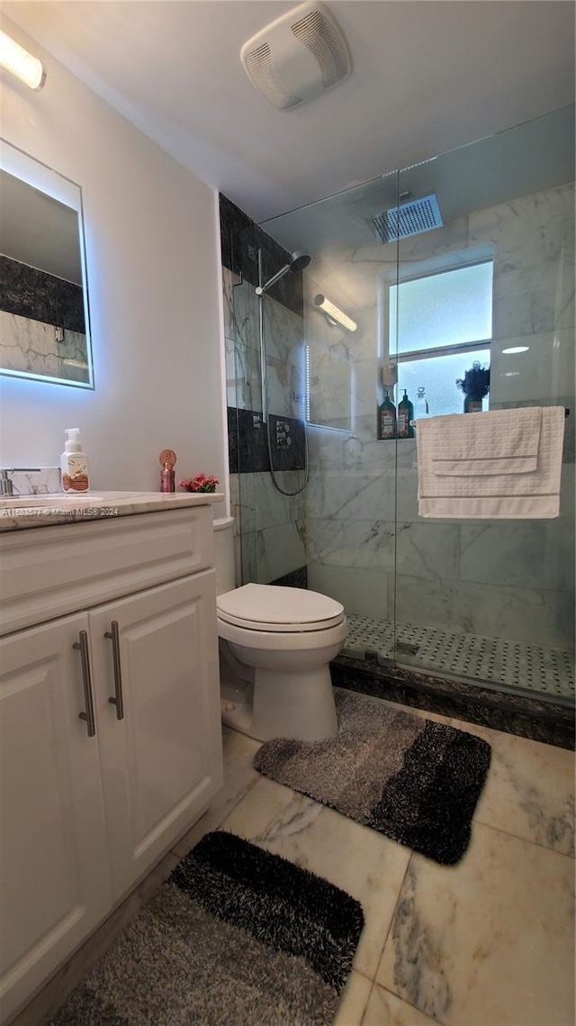 bathroom featuring vanity, toilet, and a shower with door