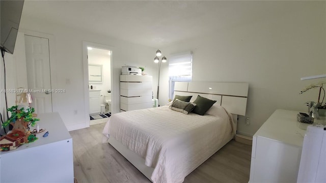 bedroom with light hardwood / wood-style floors and connected bathroom