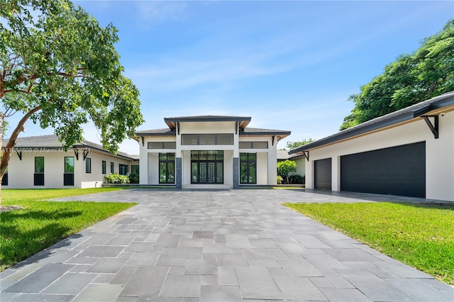 prairie-style home with a front yard and a garage