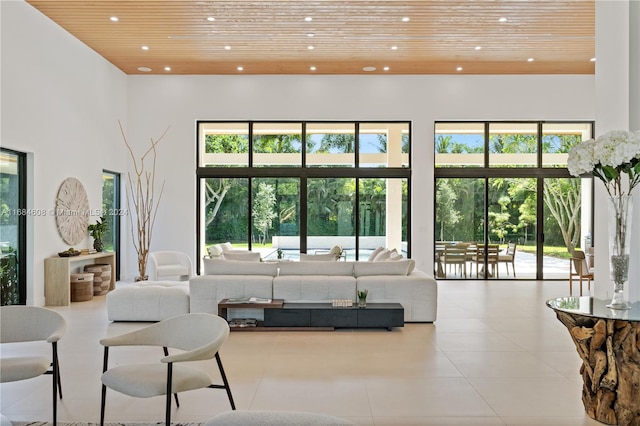 living room with a towering ceiling and wooden ceiling