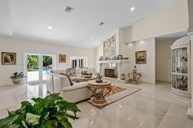 living area with high vaulted ceiling, french doors, marble finish floor, a high end fireplace, and visible vents