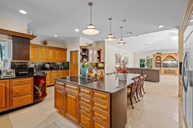 kitchen with a center island, tasteful backsplash, brown cabinets, black electric stovetop, and recessed lighting