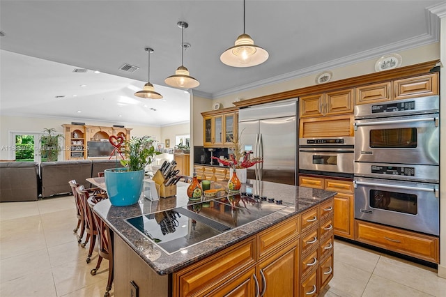kitchen with stainless steel appliances, brown cabinetry, and light tile patterned flooring