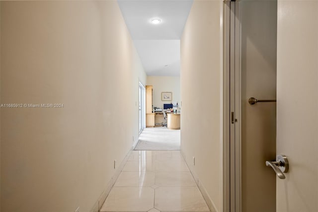 corridor featuring light tile patterned floors and baseboards