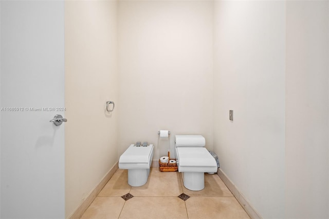 bathroom with baseboards, tile patterned floors, and toilet