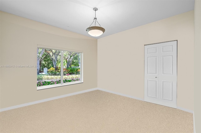empty room featuring baseboards and light colored carpet