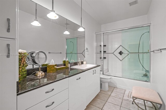 bathroom featuring vanity, enclosed tub / shower combo, toilet, and visible vents