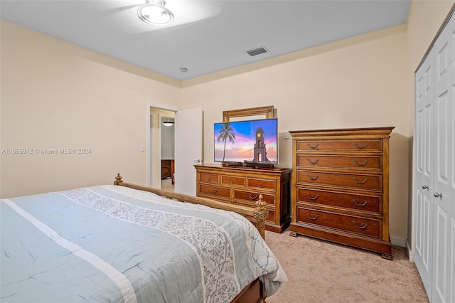 bedroom with visible vents, a closet, and light carpet
