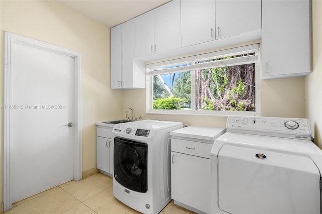 laundry area with separate washer and dryer, a sink, cabinet space, and light tile patterned floors