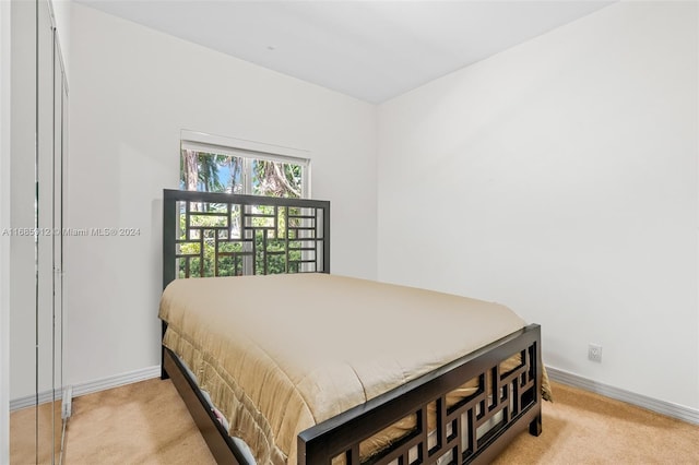 bedroom featuring baseboards and light colored carpet