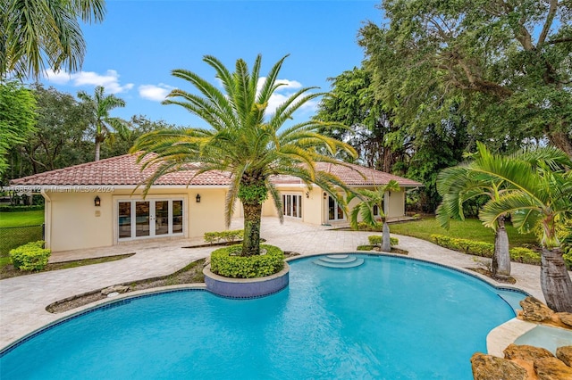 pool featuring a patio area, fence, and french doors