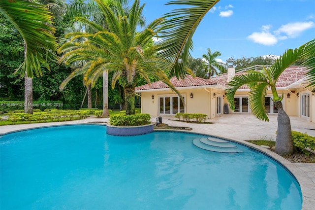 outdoor pool featuring french doors and a patio